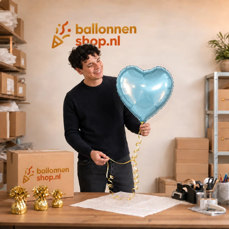 Jesse houdt de Helium Ballon Hart Licht Blauw vast in de warme werkplaats van Ballonnenshop.nl.