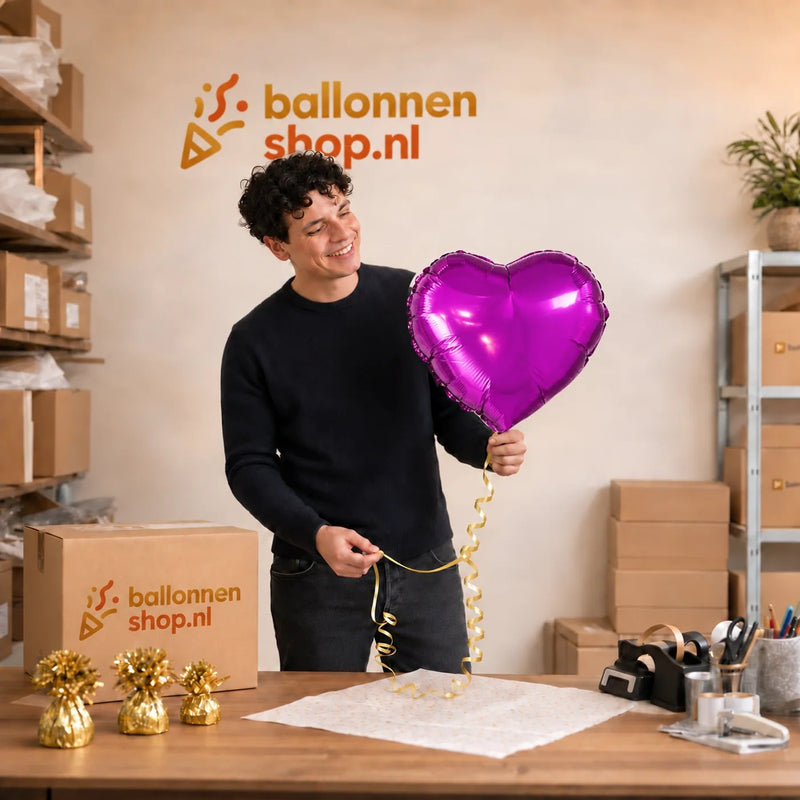 Jesse houdt de Helium Ballon Hart Paars vast in de warme werkplaats van Ballonnenshop.nl.