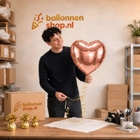 Jesse houdt de Helium Ballon Hart Rose Goud vast in de warme werkplaats van Ballonnenshop.nl.