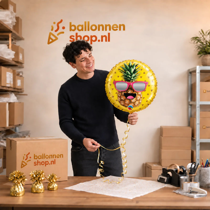 Jesse houdt de Helium Ballon Party Ananas vast in de warme werkplaats van Ballonnenshop.nl.