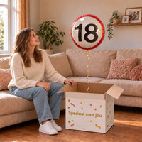 Vrouw viert 18 jaar met Ballon Verkeersbord 18 Jaar uit een cadeaudoos van Ballonnenshop.nl