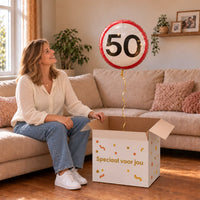 Vrouw viert 50 jaar met Ballon Verkeersbord 50 Jaar uit een cadeaudoos van Ballonnenshop.nl