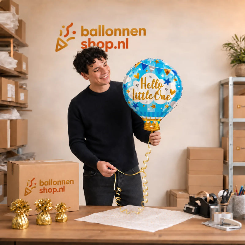 Jesse houdt de Hello Little One Ballon vast in de warme werkplaats van Ballonnenshop.nl.