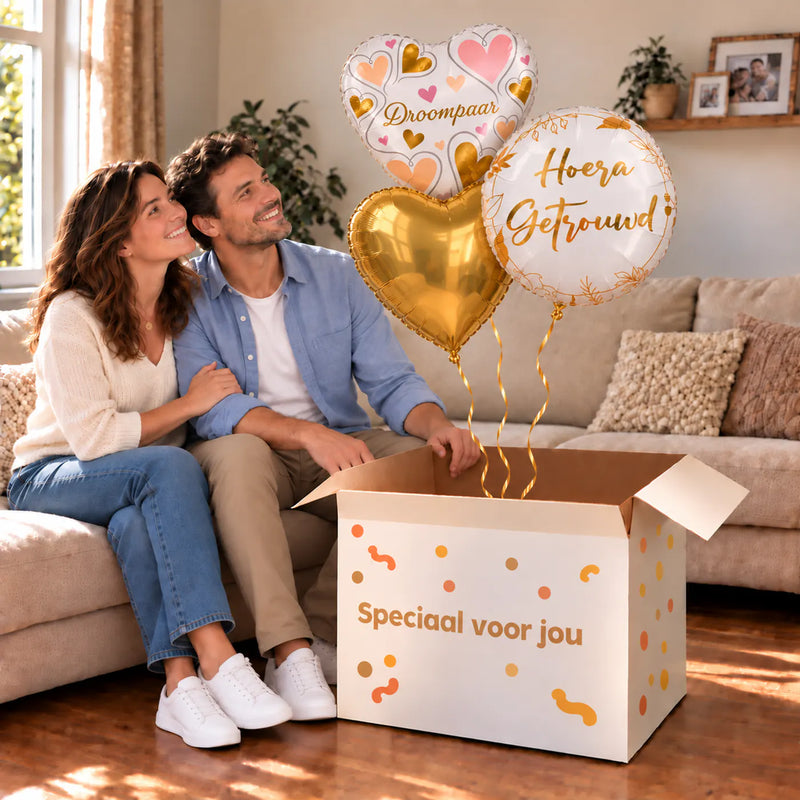 Een feestelijk huwelijksmoment met Hoera Getrouwd Droompaar Trosje boven een open Speciaal voor jou-doos in een warme woonkamer.
