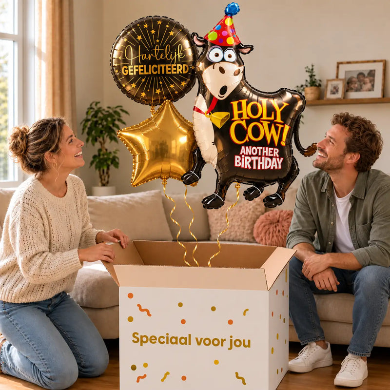 Holy Cow Birthday XL Trosje zweeft uit de Speciaal voor jou doos in een warme woonkamer, met de jarige op de bank
