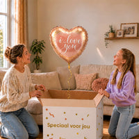 Moeder en dochter pakken een roségouden I Love You hartballon van 45 cm uit een cadeaudoos.