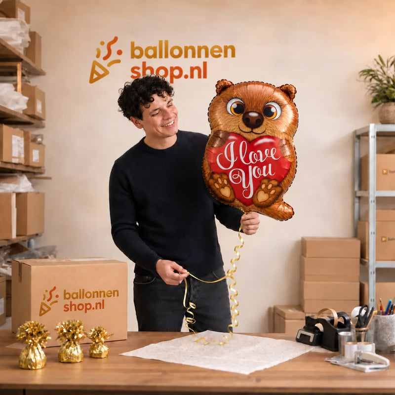 Jesse houdt de I Love You Otter Ballon vast in de warme werkplaats van Ballonnenshop.nl.