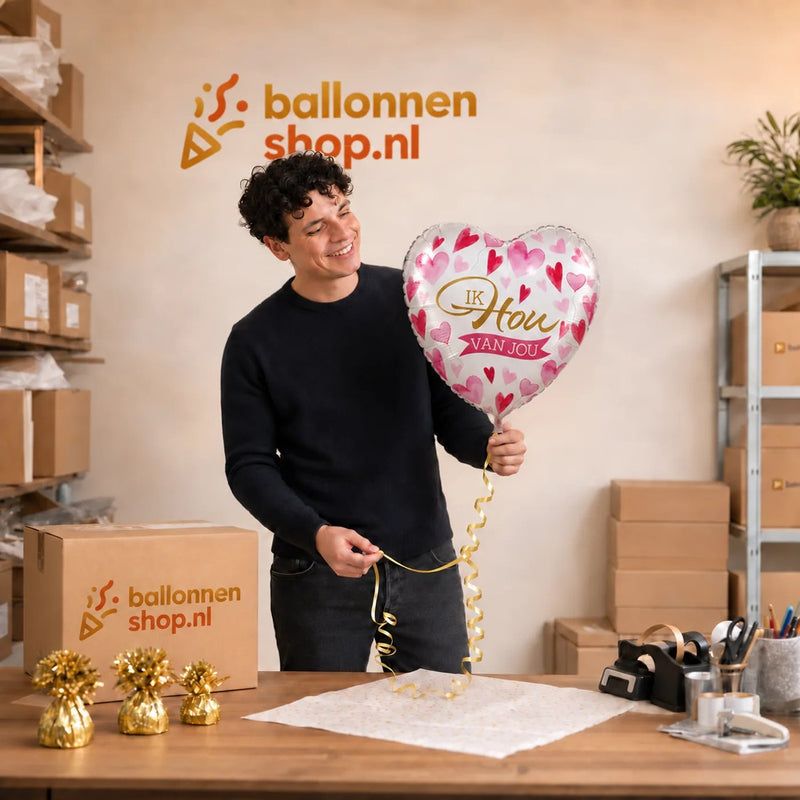 Jesse houdt de Ik Hou Van Jou Helium Ballon vast in de warme werkplaats van Ballonnenshop.nl.