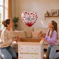 Moeder en dochter pakken een witte Ik Hou Van Jou hartballon van 45 cm met rode hartjes uit.
