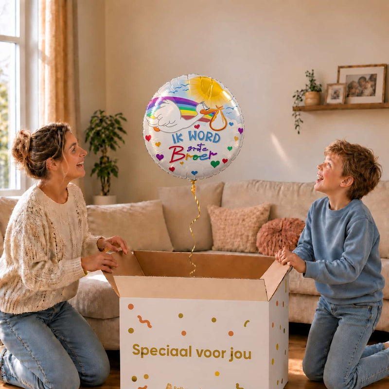 Moeder en zoon openen een cadeaudoos met een Ik Word Grote Broer ballon van 46 cm met ooievaar en regenboog.