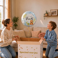 Moeder en zoon bekijken een lichtblauwe Ik Word Grote Broer ballon van 46 cm met een teddybeer boven de cadeaudoos.