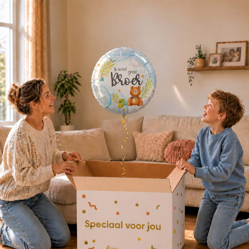 Moeder en zoon bekijken een lichtblauwe Ik Word Grote Broer ballon van 46 cm met een teddybeer boven de cadeaudoos.