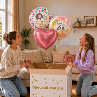 Ik Word Grote Zus Trosje: moeder en dochter pakken het heliumgevulde ballonnentrosje uit een Speciaal voor jou-doos, met natuurlijk gekrulde gouden linten.