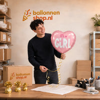 Jesse houdt de It's A Baby Girl Helium Ballon vast in de warme werkplaats van Ballonnenshop.nl.