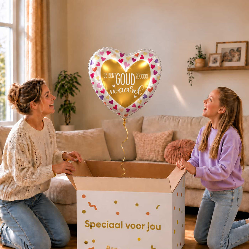 Moeder en dochter pakken een Je Bent Goud Waard hartballon van 43 cm met kleurrijke hartjes uit.