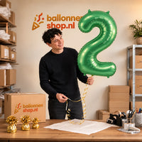Jesse houdt de 2 Jaar Cijfer Lichtgroen XL vast in de warme inpakruimte van Ballonnenshop.nl.