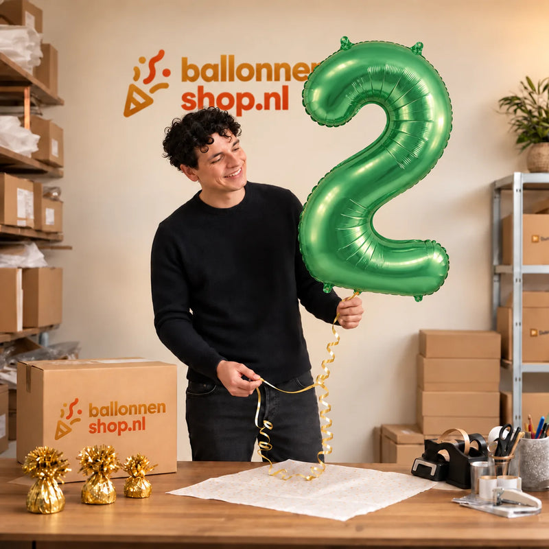 Jesse houdt de 2 Jaar Cijfer Lichtgroen XL vast in de warme inpakruimte van Ballonnenshop.nl.