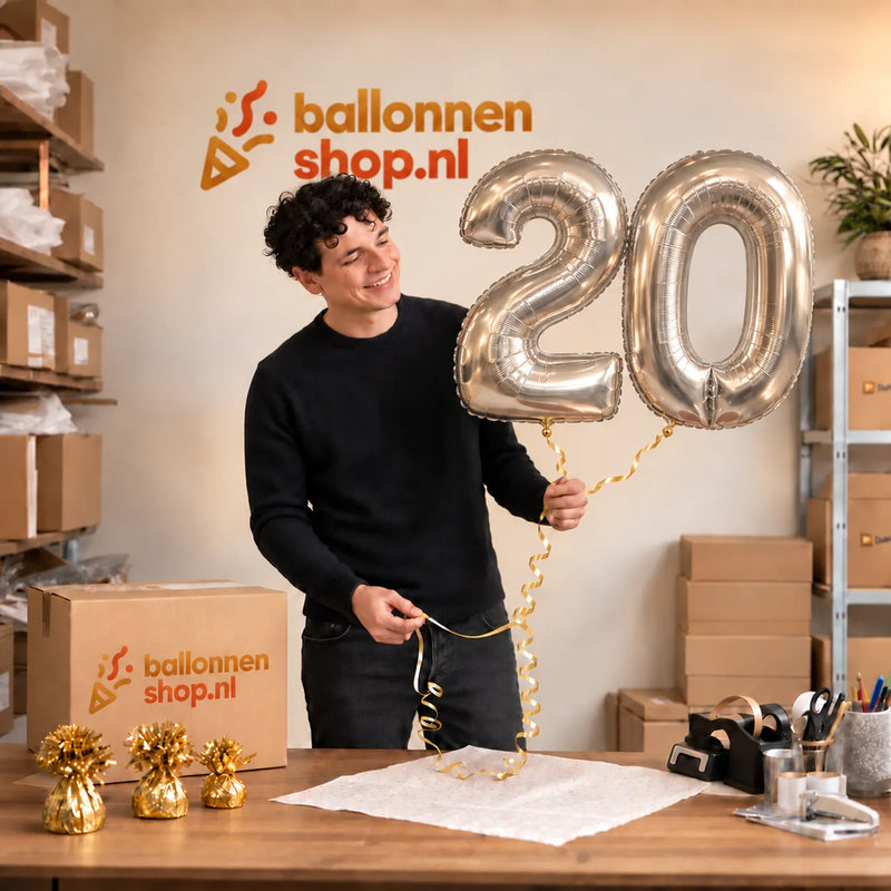 Jesse houdt de 20 Jaar Cijfer Ballonnen Zilver vast in de warme inpakruimte van Ballonnenshop.nl.