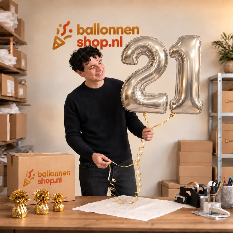 Jesse houdt de 21 Jaar Cijfer Ballonnen Zilver vast in de warme inpakruimte van Ballonnenshop.nl.