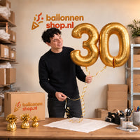 Jesse houdt de 30 Jaar Cijfer Ballonnen Goud vast in de warme inpakruimte van Ballonnenshop.nl.