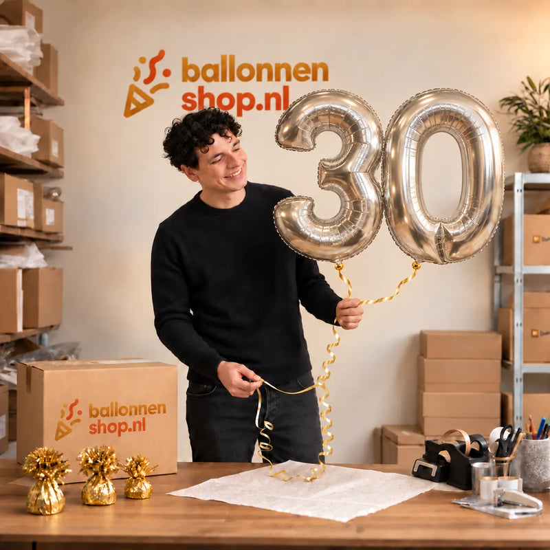 Jesse houdt de 30 Jaar Cijfer Ballonnen Zilver vast in de warme inpakruimte van Ballonnenshop.nl.