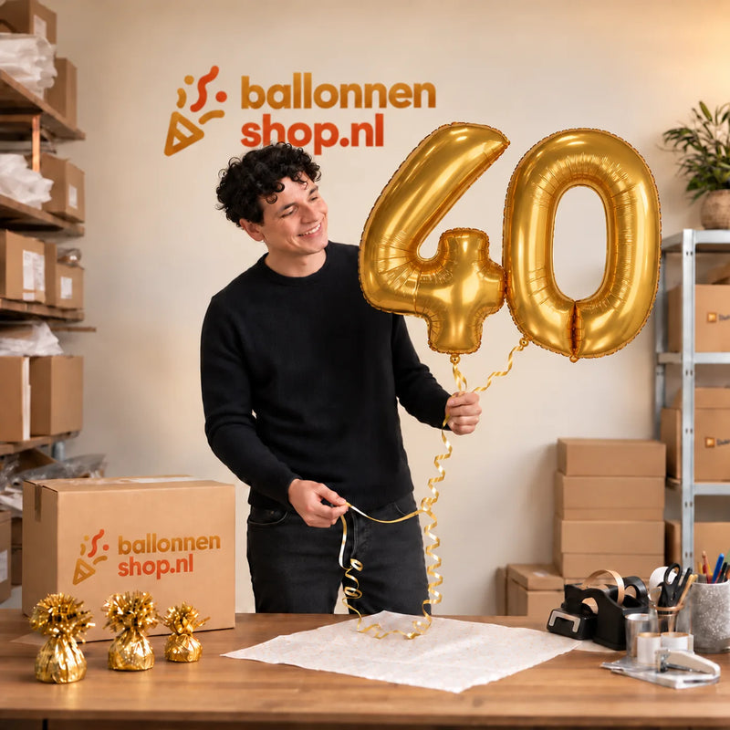 Jesse houdt de 40 Jaar Cijfer Ballonnen Goud vast in de warme inpakruimte van Ballonnenshop.nl.
