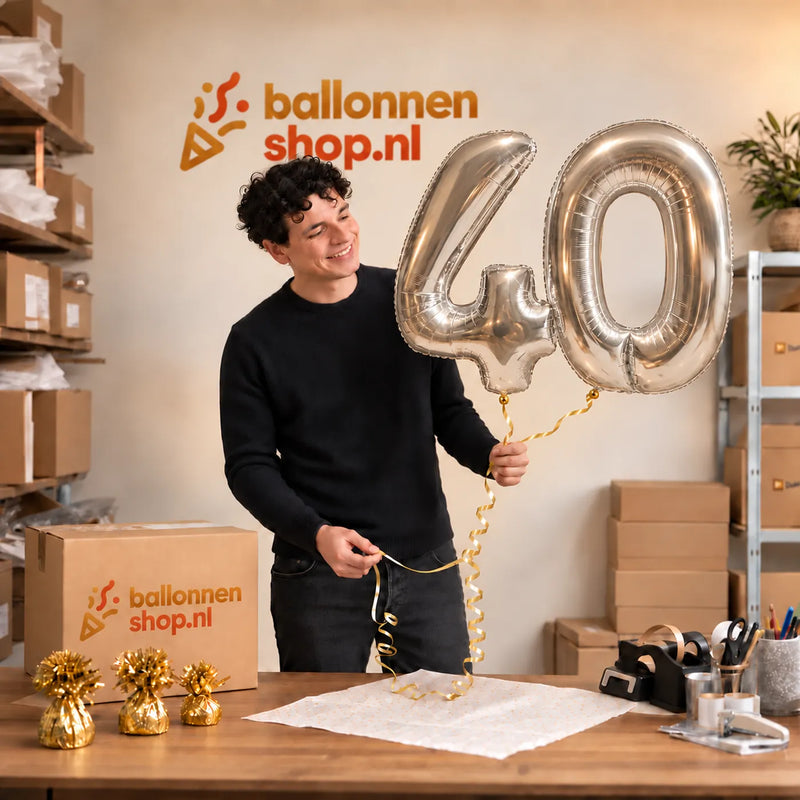 Jesse houdt de 40 Jaar Cijfer Ballonnen Zilver vast in de warme inpakruimte van Ballonnenshop.nl.