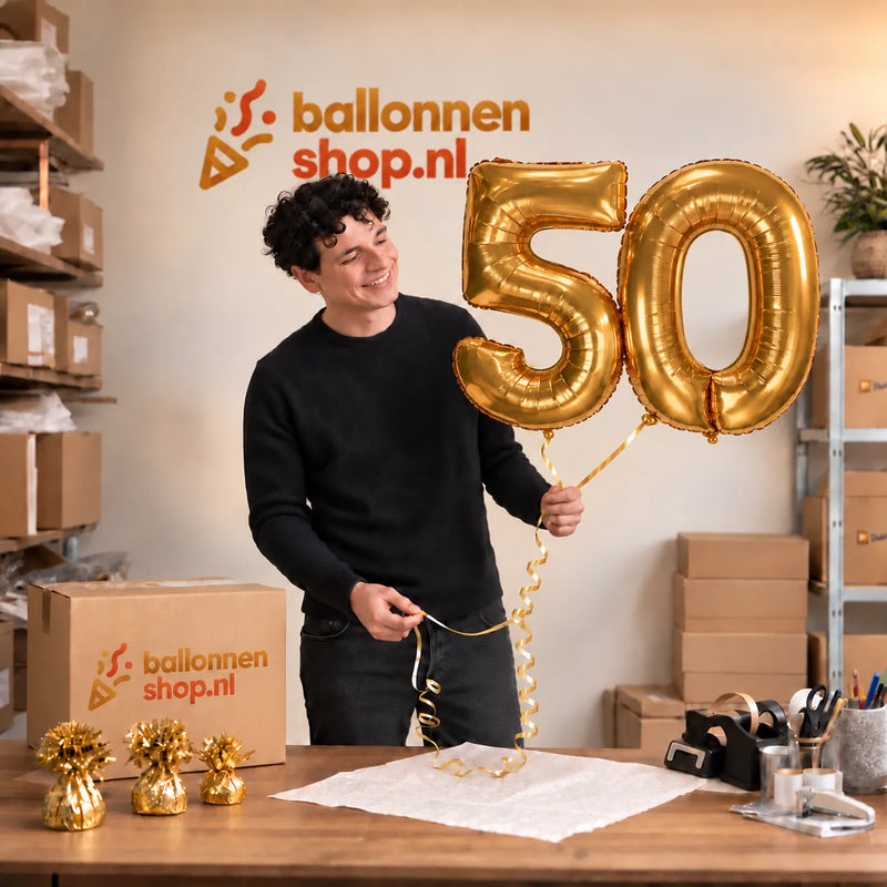 Jesse houdt de 50 Jaar Cijfer Ballonnen Goud vast in de warme inpakruimte van Ballonnenshop.nl.