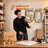 Jesse houdt de 50 Jaar Cijfer Ballonnen Zilver vast in de warme inpakruimte van Ballonnenshop.nl.