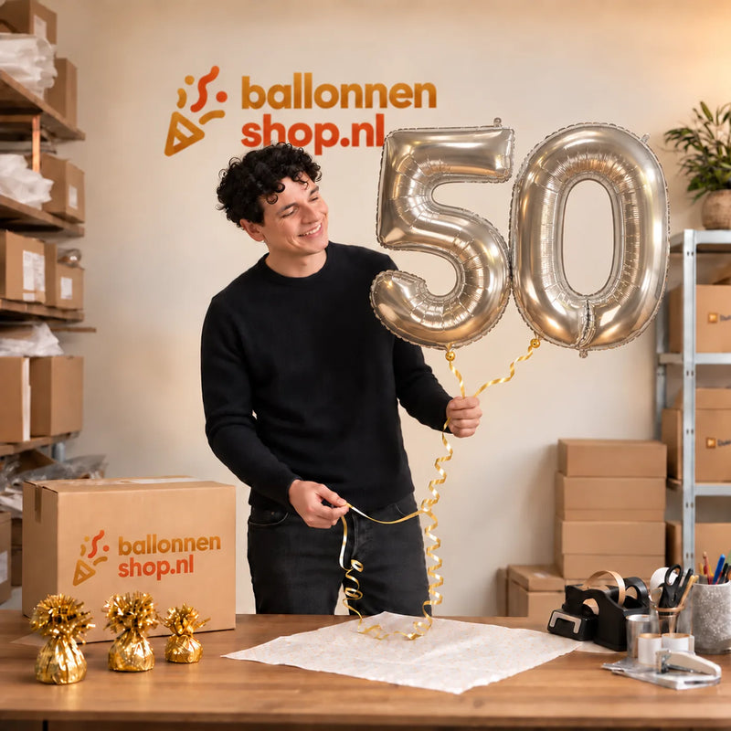 Jesse houdt de 50 Jaar Cijfer Ballonnen Zilver vast in de warme inpakruimte van Ballonnenshop.nl.