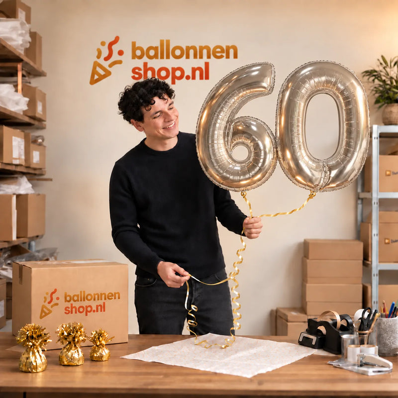 Jesse houdt de 60 Jaar Cijfer Ballonnen Zilver vast in de warme inpakruimte van Ballonnenshop.nl.