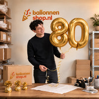 Jesse houdt de 80 Jaar Cijfer Ballonnen Goud vast in de warme inpakruimte van Ballonnenshop.nl.
