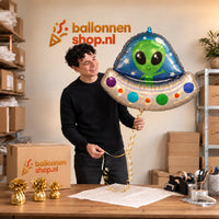Jesse houdt de Alien Helium XL Ballon vast in de warme inpakruimte van Ballonnenshop.nl.