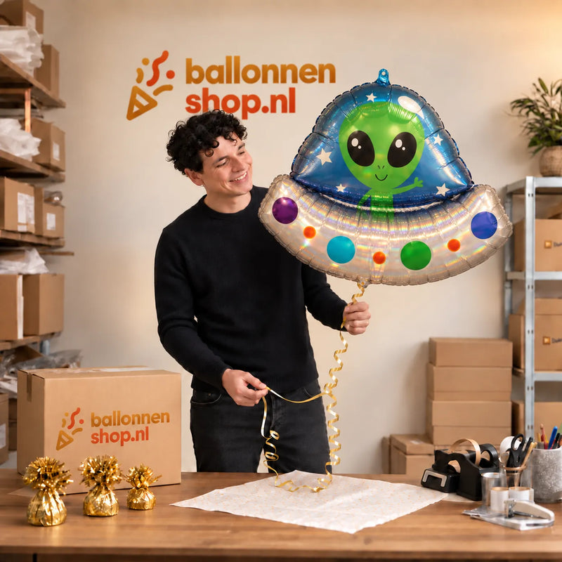 Jesse houdt de Alien Helium XL Ballon vast in de warme inpakruimte van Ballonnenshop.nl.