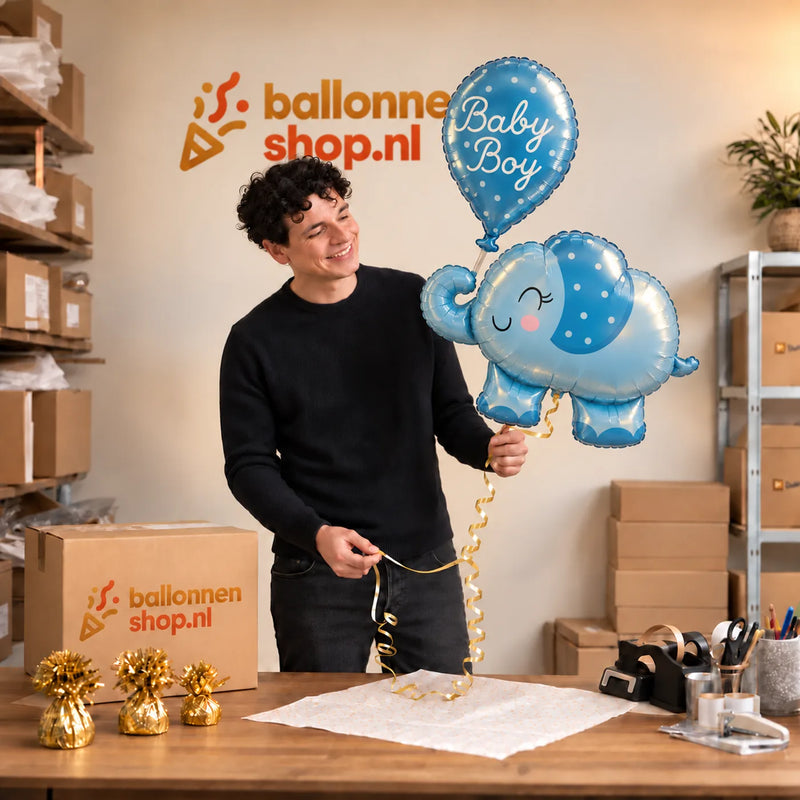 Jesse houdt de Baby Boy Blauw Olifantje XL vast in de warme inpakruimte van Ballonnenshop.nl.