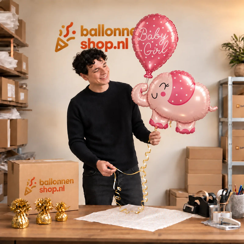 Jesse houdt de Baby Girl Roze Olifantje XL vast in de warme inpakruimte van Ballonnenshop.nl.