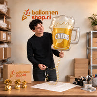 Jesse houdt de Bier Helium XL Ballon Cheers vast in de warme inpakruimte van Ballonnenshop.nl.