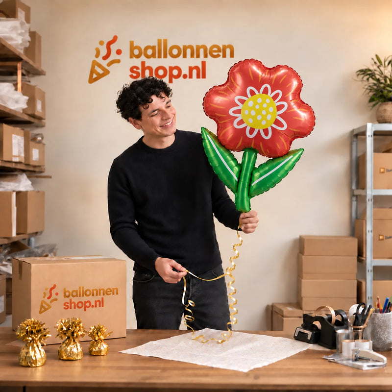 Jesse houdt de Bloem Helium XL Ballon vast in de warme inpakruimte van Ballonnenshop.nl.