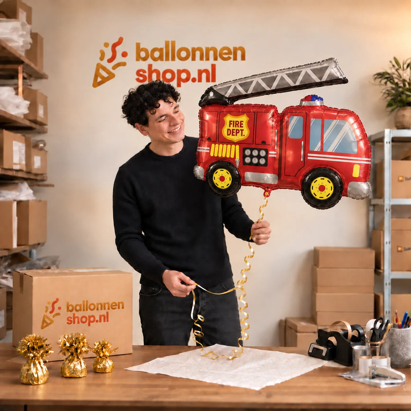 Jesse houdt de Brandweer Helium XL Ballon vast in de warme inpakruimte van Ballonnenshop.nl.