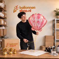 Jesse houdt de Bride To Be Schelp Helium Ballon vast in de warme inpakruimte van Ballonnenshop.nl.