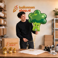 Jesse houdt de Broccoli Helium Ballon vast in de warme inpakruimte van Ballonnenshop.nl.