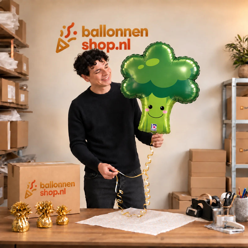 Jesse houdt de Broccoli Helium Ballon vast in de warme inpakruimte van Ballonnenshop.nl.