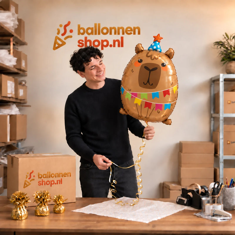 Jesse houdt de Capybara Helium Ballon vast in de warme inpakruimte van Ballonnenshop.nl.