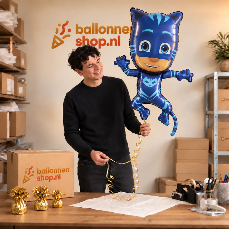 Jesse houdt de Catboy PJ Masks Helium XL Ballon vast in de warme inpakruimte van Ballonnenshop.nl.