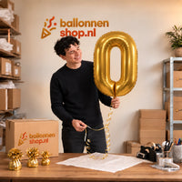 Jesse houdt de Cijfer 0 Helium Ballon Goud vast in de warme inpakruimte van Ballonnenshop.nl.