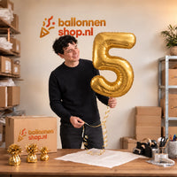 Jesse houdt de Cijfer 5 Helium Ballon Goud vast in de warme inpakruimte van Ballonnenshop.nl.