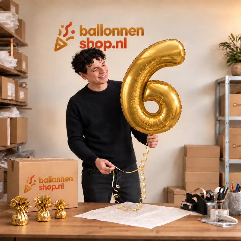 Jesse houdt de Cijfer 6 Helium Ballon Goud vast in de warme inpakruimte van Ballonnenshop.nl.