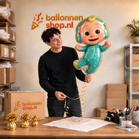 Jesse houdt de CoComelon Helium XL Ballon vast in de warme inpakruimte van Ballonnenshop.nl.