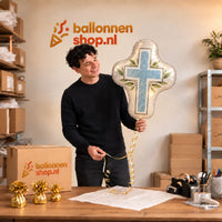 Jesse houdt de Communie Kruis Helium XL Ballon vast in de warme inpakruimte van Ballonnenshop.nl.