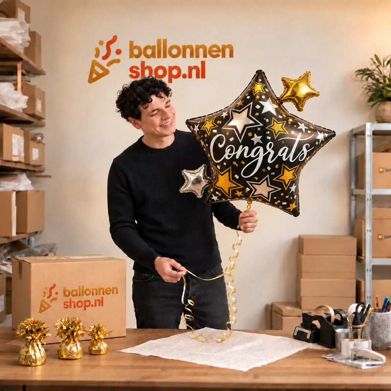 Jesse houdt de Congrats Ster Helium XL Ballon vast in de warme inpakruimte van Ballonnenshop.nl.